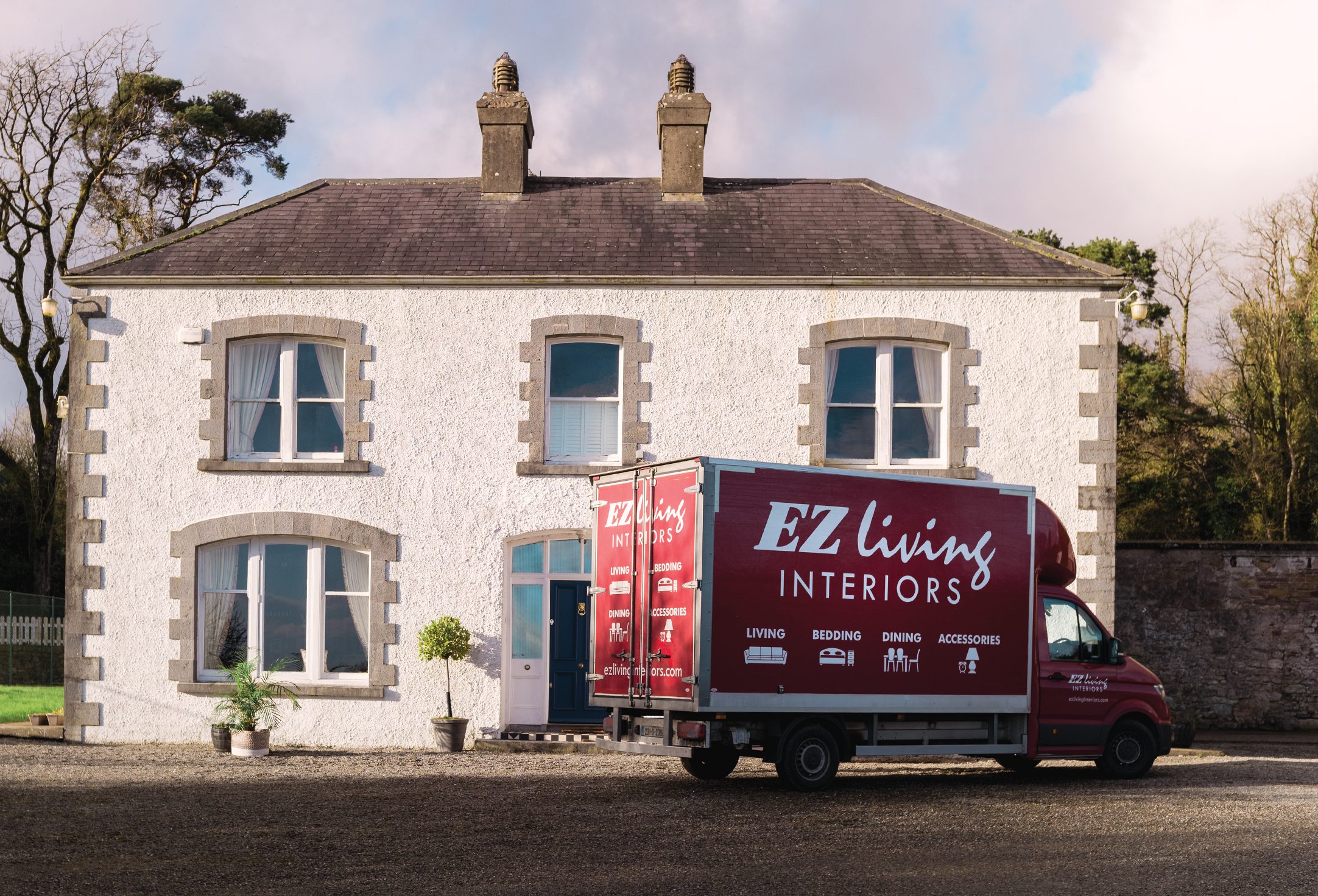 EZ Living Interiors delivery van parked outside a country house